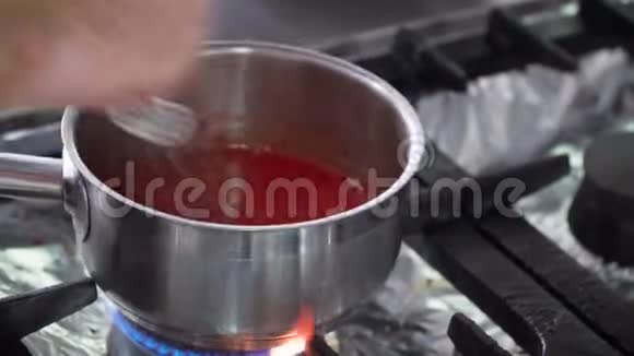 厨师把酱汁或糖霜放在平底锅里站在煤气炉上加热手动作特写视频的预览图