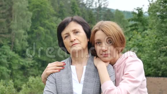 一幅严肃的母亲和成年女儿在夏天群山背景下的肖像快乐的晚年视频的预览图