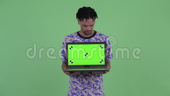 穿着衣服的非洲年轻人展示笔记本电脑视频的预览图