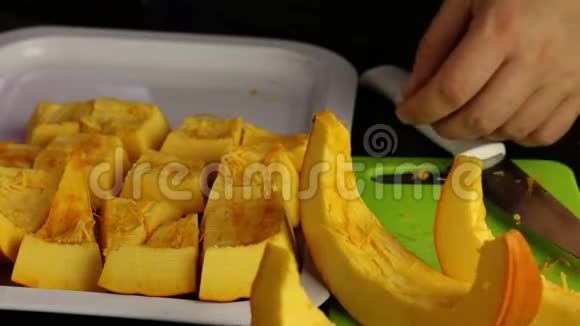 一个人把一个橙色的南瓜切成碎片放在托盘上世界素食日视频的预览图