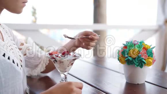 在海滨餐馆吃甜点的快乐年轻漂亮女孩的肖像视频的预览图