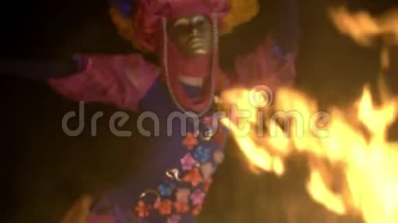 漆黑的夜晚熊熊燃烧的火舞神秘女孩穿着一件特别的西装戴着一个金色的面具遮住了脸视频的预览图