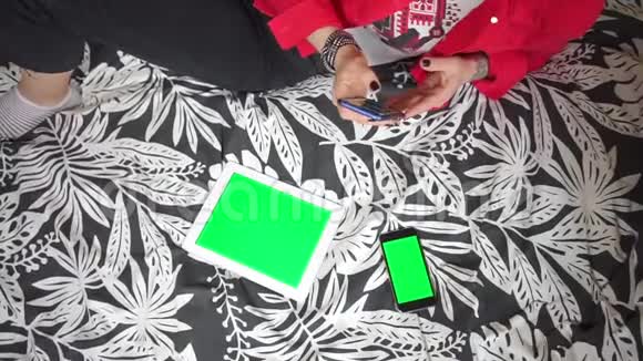 女孩用手机躺着平板电脑和智能手机视频的预览图