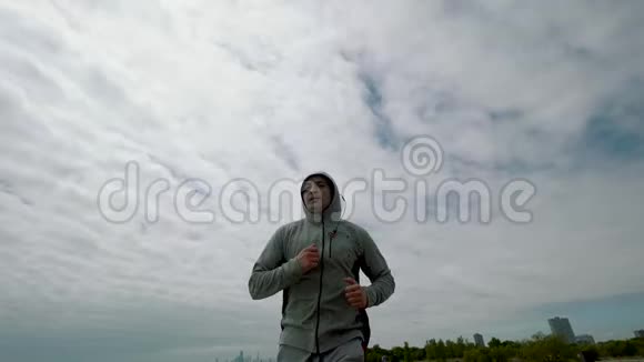 一个年轻的运动员正在从事体育运动沿着湖边跑步直到山顶视频的预览图