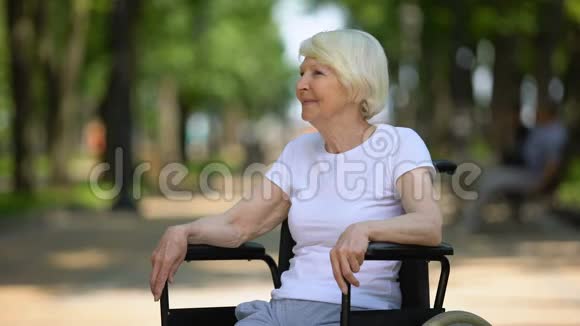 坐轮椅的快乐老年女性在公园享受阳光康复视频的预览图