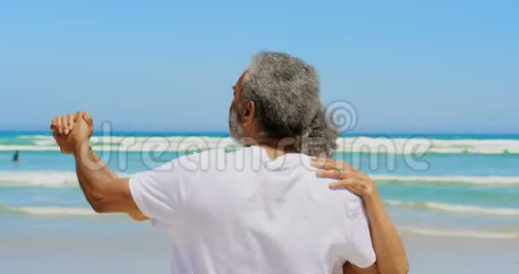 浪漫的活跃的非裔美国人夫妇在海滩上一起跳舞的正面景色视频的预览图