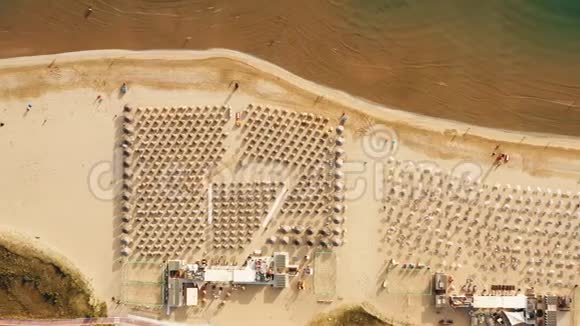 顶景无人驾驶飞机飞到夏海海岸上空完美的公共沙滩一排排椅子和雨伞视频的预览图