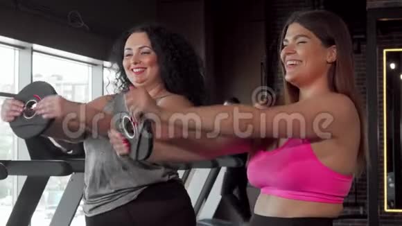 漂亮的大个子女人和她的朋友在健身房锻炼视频的预览图
