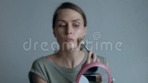 女人在一面圆镜子面前化妆视频的预览图