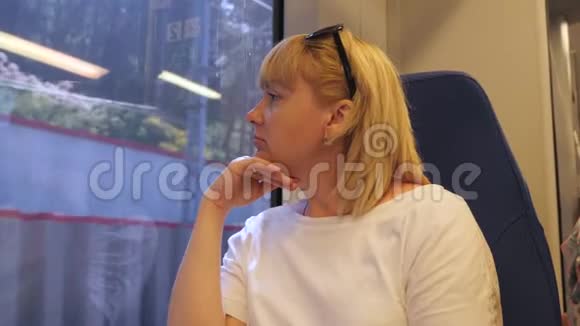 一个女人坐火车旅行坐在火车上的女人看着窗外旅游和旅游的概念视频的预览图