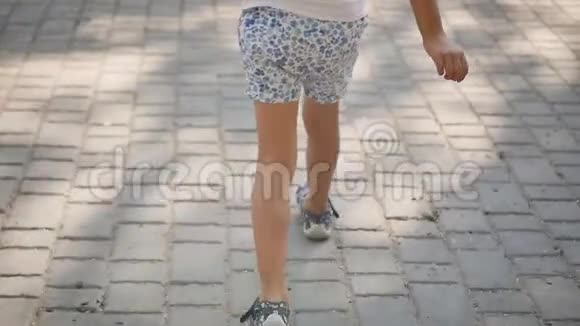 一个穿短裤的小女孩正在夏天的城市里散步小女孩的腿特写镜头慢动作视频的预览图