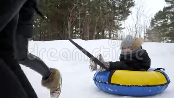 快乐的父母在冬天的公园里跑着把儿子滑到油管里视频的预览图