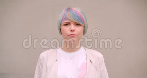 一位年轻漂亮的白种人女性染着头发看着室外的摄像机墙上挂着一幅特写照片视频的预览图