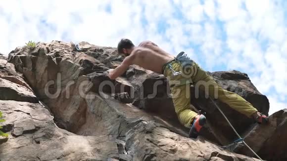慢速运动爬坡瞬间和细节运动男子攀岩者裸躯干爬上悬崖视频的预览图
