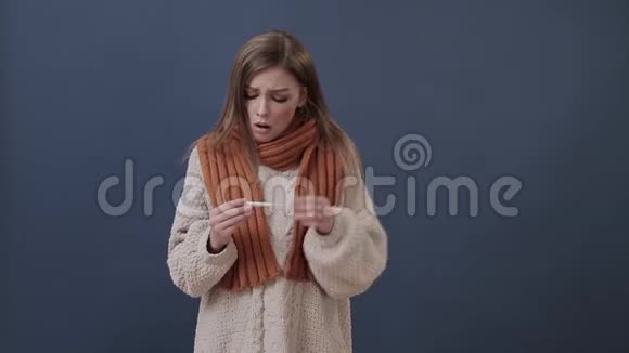 裹着温暖围巾的生病女孩测量温度视频的预览图