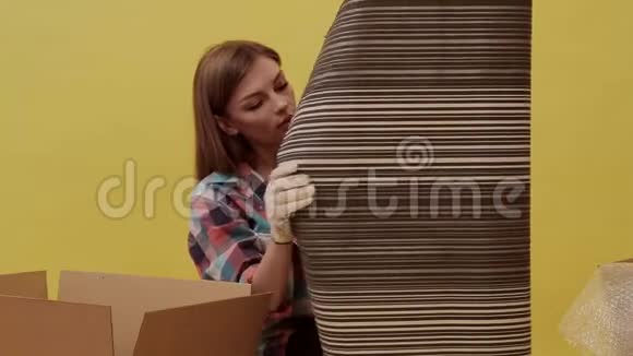一个年轻的女人动起来拿起墙纸来修理视频的预览图