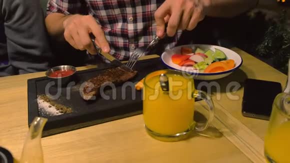 人吃中烤牛肉牛排在咖啡馆的黑木板上端着视频的预览图