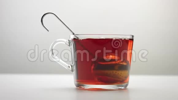 一个注入茶的勺子缓慢地移动到透明的茶杯里视频的预览图