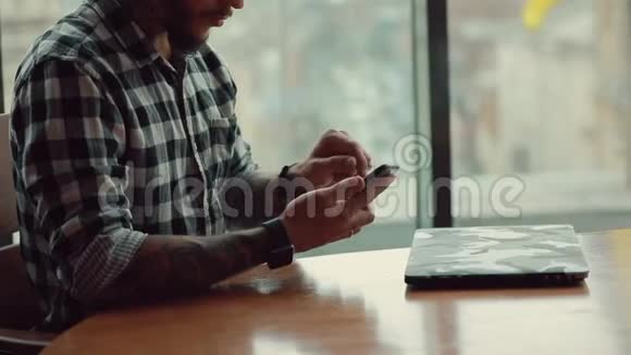 时尚帅气的自由职业者坐在咖啡馆里用笔记本电脑工作视频的预览图