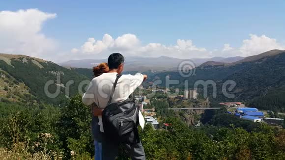 年轻夫妇来到旅游城市杰尔穆克站在山上手工地互相展示哪些风景如画的地方视频的预览图