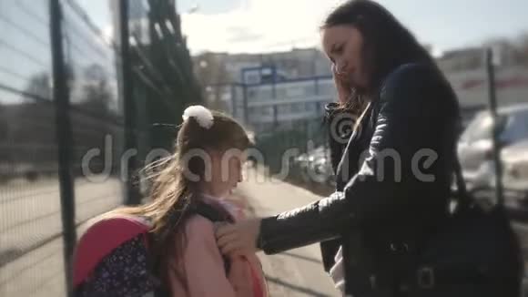 妈妈带女儿上学穿夹克的妈妈带着背包带着女儿回学校视频的预览图