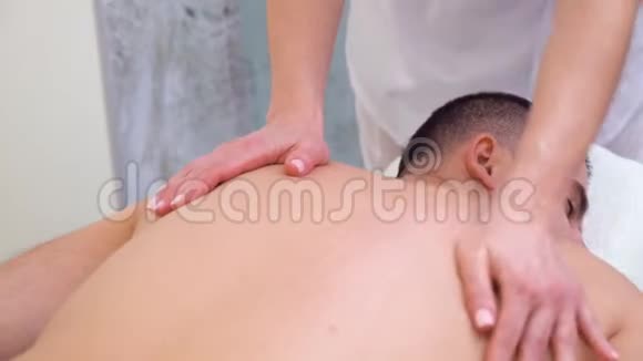 女性双手在水疗沙龙做男性患者上背部放松按摩视频的预览图