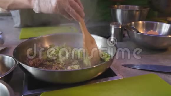 厨师用橄榄油搅拌洋葱和芹菜丁视频的预览图