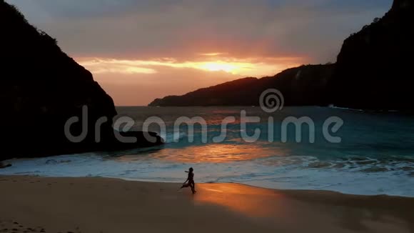 在Kelingking海滩女孩们在美丽的夕阳下奔跑视频的预览图