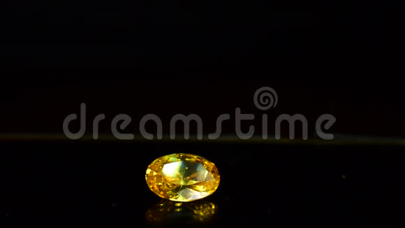 黄色宝石是一种具有闪光和美丽反射的宝石在玻璃地板上视频的预览图