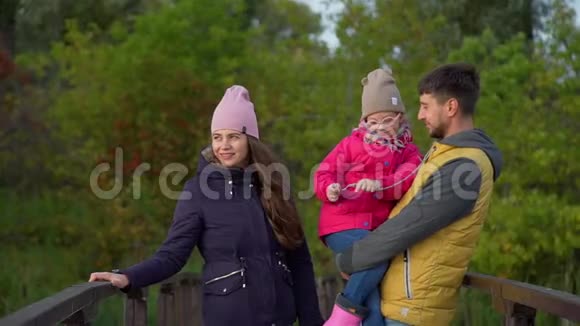 秋季木桥上的家庭休息视频的预览图