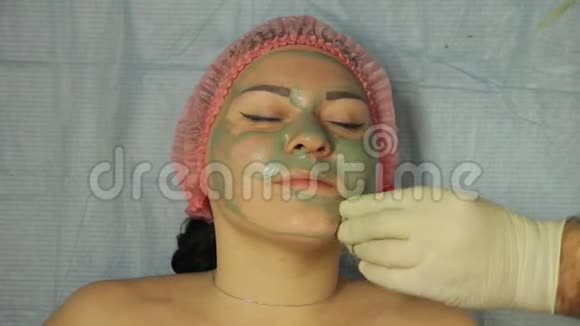 美容师双手戴着手套用棉垫把口罩从女人脸上移开视频的预览图