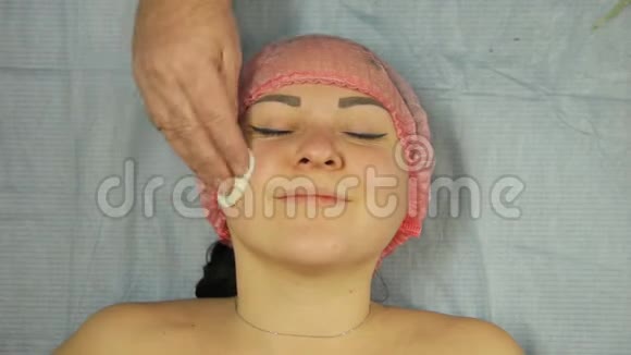 美容师的手用棉垫给女人的脸保湿视频的预览图