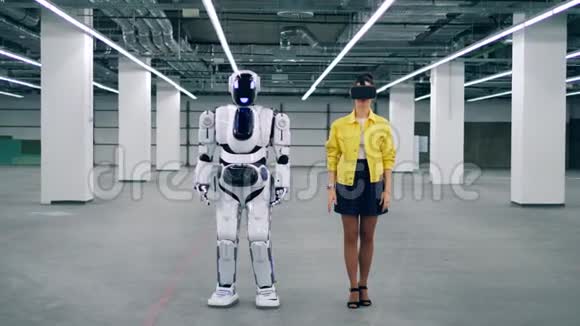 一位戴着VR眼镜的年轻女子和一个机器人正在一起移动视频的预览图