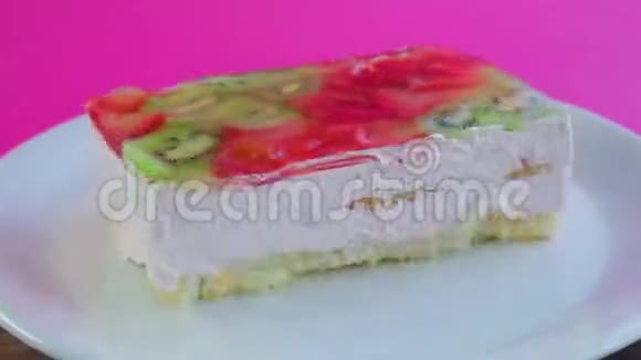 白色盘子上的果冻水果蛋糕旋转一圈圈起来视频的预览图