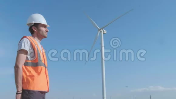 在阳光明媚的日子里工程师们在风电场里讨论反对涡轮机的问题视频的预览图