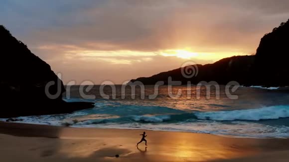 那个人在巴厘岛海边美丽的日落处奔跑视频的预览图