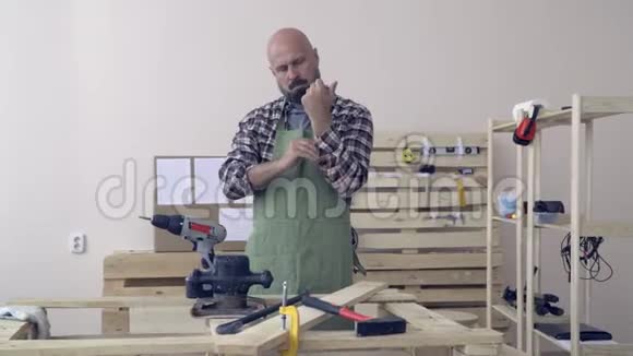 一个严肃的木匠卷起衬衣的袖子把胳膊交叉在胸前视频的预览图