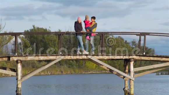 一家人在湖边的木桥上休息视频的预览图