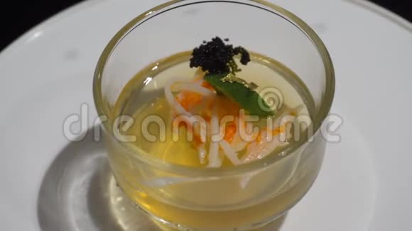果冻布丁在透明的杯子里玫瑰色和金叶在旋转视频的预览图
