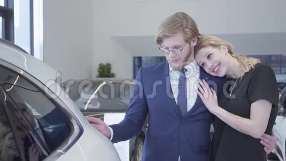 漂亮的成功夫妻适合在汽车经销商选择一辆新汽车汽车视频的预览图