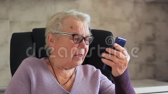 老年妇女带移动设备的祖母视频的预览图