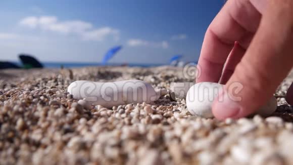 假日放松的游客在海滩上玩小石头视频的预览图