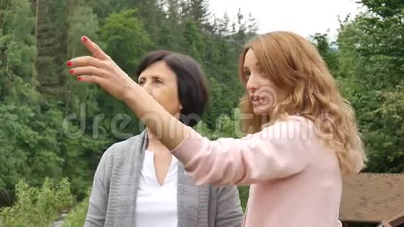 两个女人年轻的和年长的正在眺望远方在群山和视频的预览图