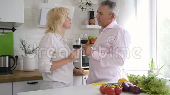 老人和妻子微笑着交谈在灯光室里拿着酒视频的预览图