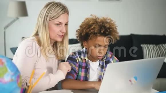 美国妇女正在向非洲男孩展示笔记本电脑互联网连接视频的预览图