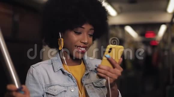 年轻的非洲裔美国妇女在乘坐公共交通工具时有一个视频电话城市灯光背景视频的预览图