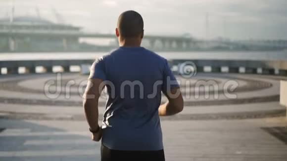 非洲孤独的跑步者在城市堤坝上做有氧运动视频的预览图