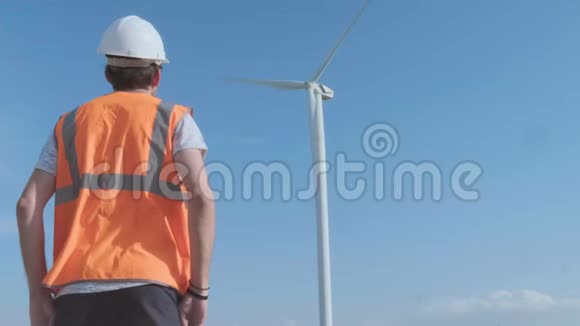 在阳光明媚的日子里工程师们在风电场里讨论反对涡轮机的问题视频的预览图