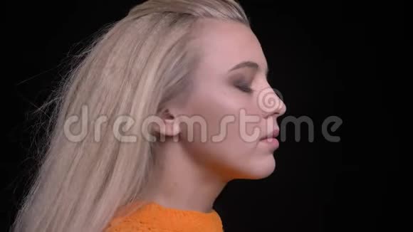 年轻迷人的白种人女性的特写镜头长着一头金发转向镜头向前看视频的预览图