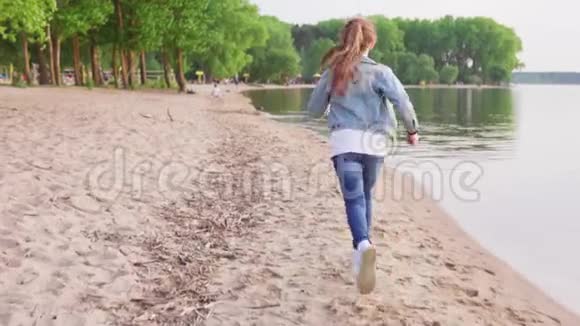 夏天女孩在沙滩上沿着海岸线奔跑视频的预览图